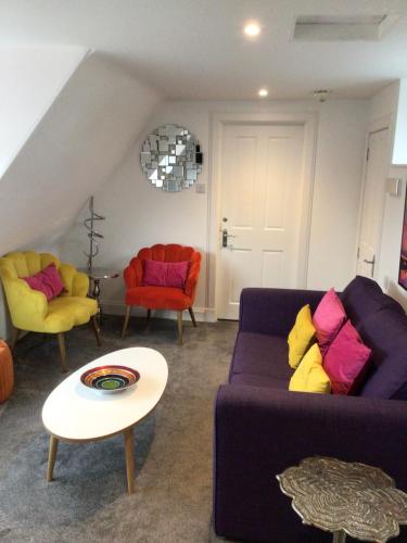 a living room with two couches and a table at St Duthus Hotel Apartment in Tain