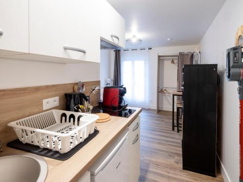 a kitchen with a counter top with a dish rack at Résidence GABRIELLE in Le Havre