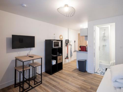 a living room with a television and a table and stool at Résidence GABRIELLE in Le Havre