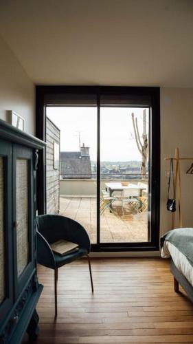 une chambre avec une porte coulissante en verre donnant sur un patio dans l'établissement Gîte Trou Life, à Bozouls