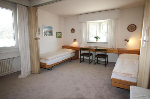 una camera da letto con scrivania, letto e tavolo di Residenza Lagrev 1 1 2 Zimmerwohnung Nr 107 - Typ 15B - 1 Etage - Süd a Sils Maria
