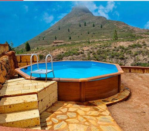 uma banheira de hidromassagem com uma montanha ao fundo em La Casita de Tila em Ifonche