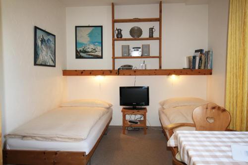 una camera con due letti e una tv di Residenza Lagrev Studio Nr 113 - Typ 10A - 1 Etage - Ost a Sils Maria