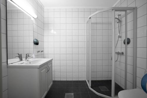 a white bathroom with a sink and a shower at Smuksjøseter Fjellstue in Høvringen