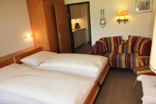 ein Hotelzimmer mit 2 Betten und einem Stuhl in der Unterkunft Residenza Lagrev 1 Zimmerwohnung Nr 228 - Typ 11A - 2 Etage - Ost in Sils Maria