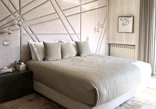 Schlafzimmer mit einem großen Bett mit einem Kopfteil aus Holz in der Unterkunft Villa Majestueuse 5 étoiles à Casablanca in Casablanca