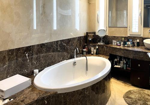 Villa Majestueuse 5 étoiles à Casablanca في الدار البيضاء: حمام مع حوض أبيض كبير في منضدة