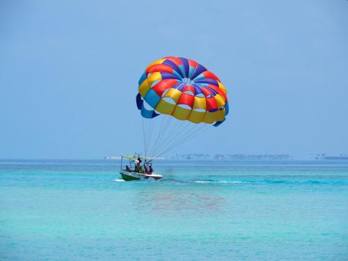 a person riding a parachute in the water at Club Kaafu Maldives in Dhiffushi