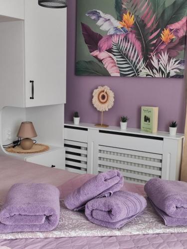 a bedroom with purple walls and a bed with purple towels at AMORE Obzor in Obzor