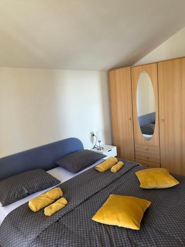 um quarto com 2 camas e almofadas amarelas em Kuća za odmor Viktoria em Opatija