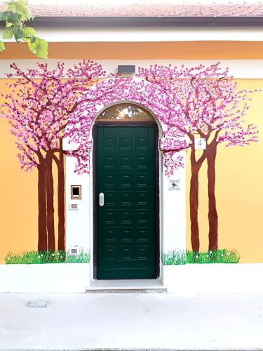 a house with a green door and trees painted on it at La Casa Di Lucia in San Vito Chietino