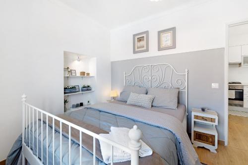 ein weißes Schlafzimmer mit einem Bett und einer Treppe in der Unterkunft Casa Lomba in Colares
