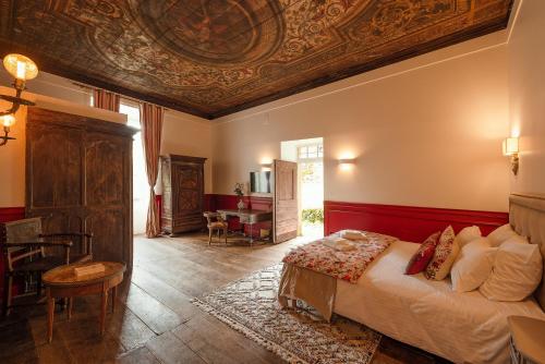 sypialnia z dużym łóżkiem i kasetonowym sufitem w obiekcie Manoir de Laroque Delprat w mieście Autoire