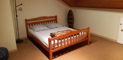 - une chambre avec un lit en bois et 2 oreillers dans l'établissement maison 475 bis a parentis, à Parentis-en-Born