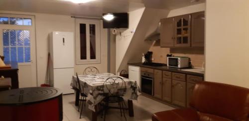 une cuisine avec une table et une petite cuisine avec une table et des chaises dans l'établissement maison 475 bis a parentis, à Parentis-en-Born