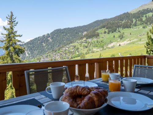 a table with a plate of food on a balcony at Apartment Baudrier A28 by Interhome in Verbier
