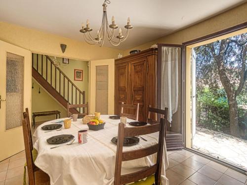 uma sala de jantar com uma mesa e uma grande janela em Holiday Home Le Counillier by Interhome em Fréjus