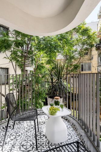 a patio with a table and chairs on a balcony at Mate GEORGE - By HOMY in Tel Aviv