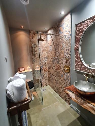 a bathroom with a shower and a sink and a mirror at Le Petit Chateau & William de Percy in Otterburn