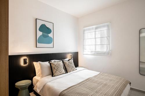 a bedroom with a bed and a window at Mate GEORGE - By HOMY in Tel Aviv