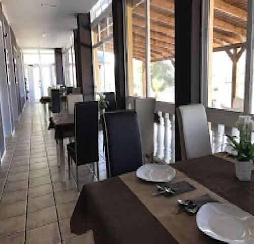 a dining room with a table and chairs and windows at Casa Horadada in Algorfa