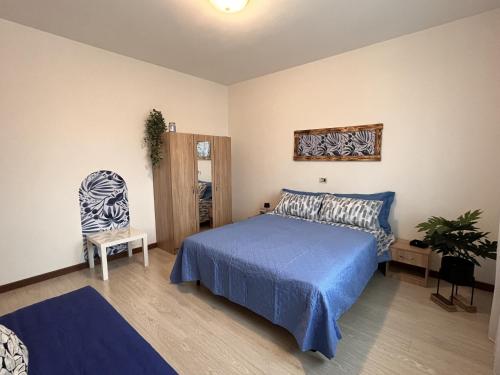 a bedroom with a blue bed and a chair at Ornella's apartment - Relax near Venice in Boion