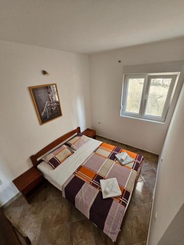 een slaapkamer met een bed en een raam bij Apartmani Vanja 2 in Kotor