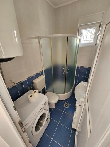 een kleine badkamer met een wasmachine en een toilet bij Apartmani Vanja 2 in Kotor