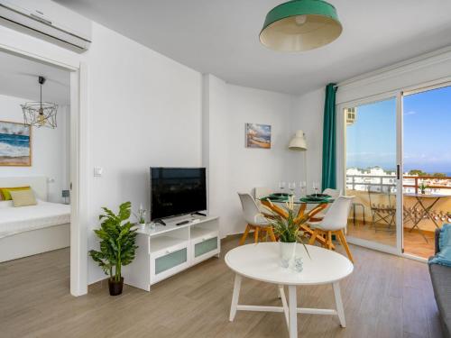 un soggiorno con tavolo e TV di Apartment Apartamento Duquesa de España-1 by Interhome a Torremolinos