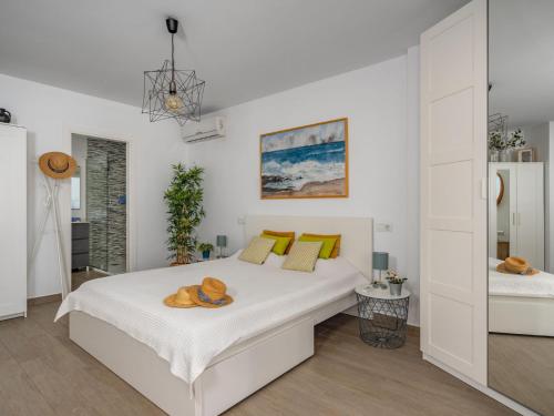 una camera da letto bianca con un letto con cuscini gialli di Apartment Apartamento Duquesa de España-1 by Interhome a Torremolinos