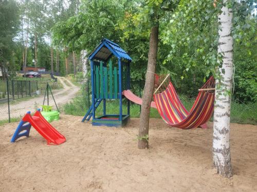 un parque infantil con 2 hamacas en la arena en Lusesita, 
