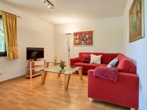 - un salon avec un canapé rouge et une table dans l'établissement Apartment Fieke by Interhome, à Frankenau