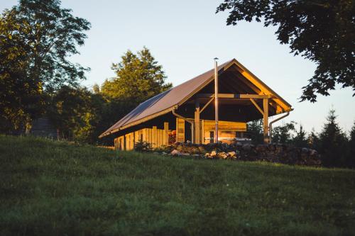 a large building with a pitched roof on a hill at Muuski glempings in Korneti