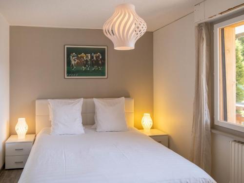 ein Schlafzimmer mit einem weißen Bett mit zwei Lampen in der Unterkunft Apartment Stem 2 by Interhome in Verbier