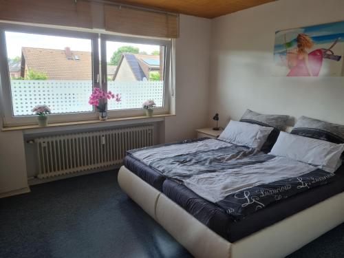 een slaapkamer met een bed en 2 ramen bij Ferienwohnung Eichhörnchen in Krefeld