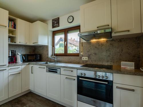 una cocina con armarios blancos y una ventana en Holiday Home Quelle by Interhome en Dittishausen