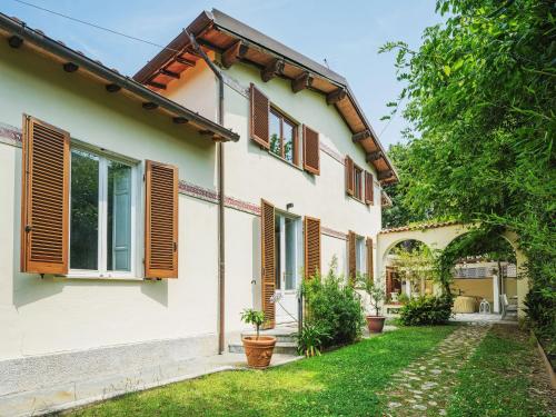 a white house with wooden shutters and a yard at Holiday Home Villa Le Stelle by Interhome in Fiumetto