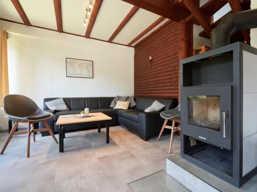 ein Wohnzimmer mit einem Sofa und einem Kamin in der Unterkunft Holiday Home Am Sternberg 74 by Interhome in Frankenau