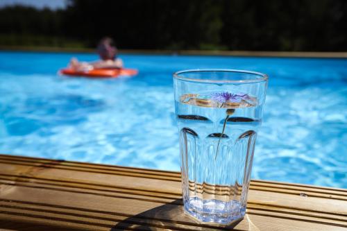 een glazen vaas op een tafel naast een zwembad bij Moje Miejsce Kazimierz in Kazimierz Dolny