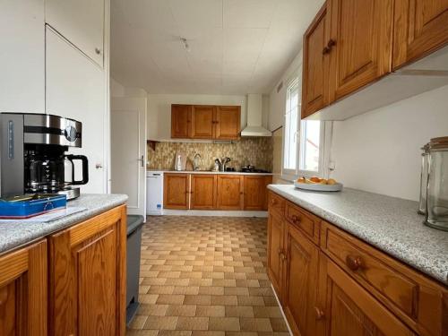 une cuisine avec des armoires en bois et un comptoir dans l'établissement Maisonnette - jardin extérieur, à Champagne-sur-Seine