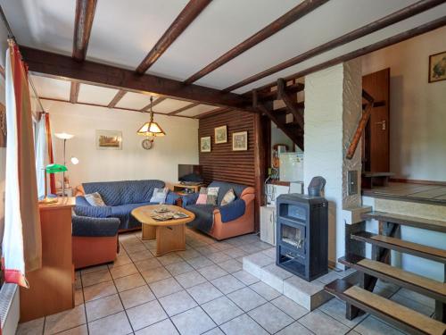 salon z kanapami i piecem opalanym drewnem w obiekcie Holiday Home Am Sternberg 105 by Interhome w mieście Frankenau
