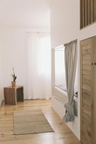 a bedroom with a bed and a window at Sãone Guesthouse - Coworking & Retreat Location in Ericeira