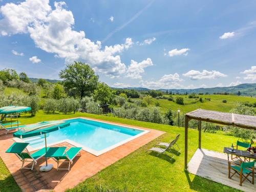uma imagem de uma piscina num quintal com cadeiras e uma mesa em Apartment L'Angolo di Uzzano by Interhome em Greve in Chianti