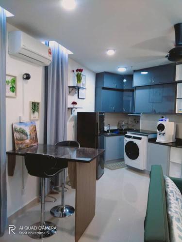 a kitchen with blue cabinets and a counter top at Qilala DualView by The Shore in Kota Kinabalu
