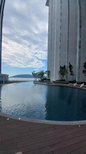 a large swimming pool in front of a large building at Qilala DualView by The Shore in Kota Kinabalu