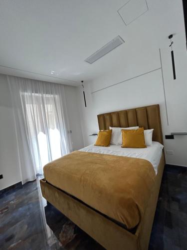 una camera da letto con un letto con cuscini gialli e una finestra di Core e core a Napoli