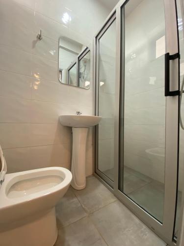 a bathroom with a toilet sink and a shower at Mayama Residences in Accra