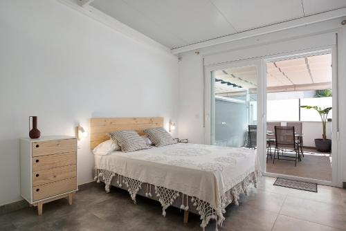 a white bedroom with a large bed and a balcony at Mariola in Novo Sancti Petri