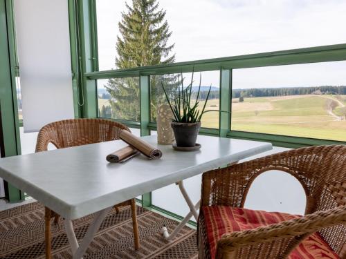 DittishausenにあるApartment F 32 by Interhomeの大きな窓のある客室で、テーブルと椅子が備わります。