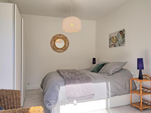a white bedroom with a bed and a mirror at Holiday Home Ker Bernic by Interhome in Piriac-sur-Mer